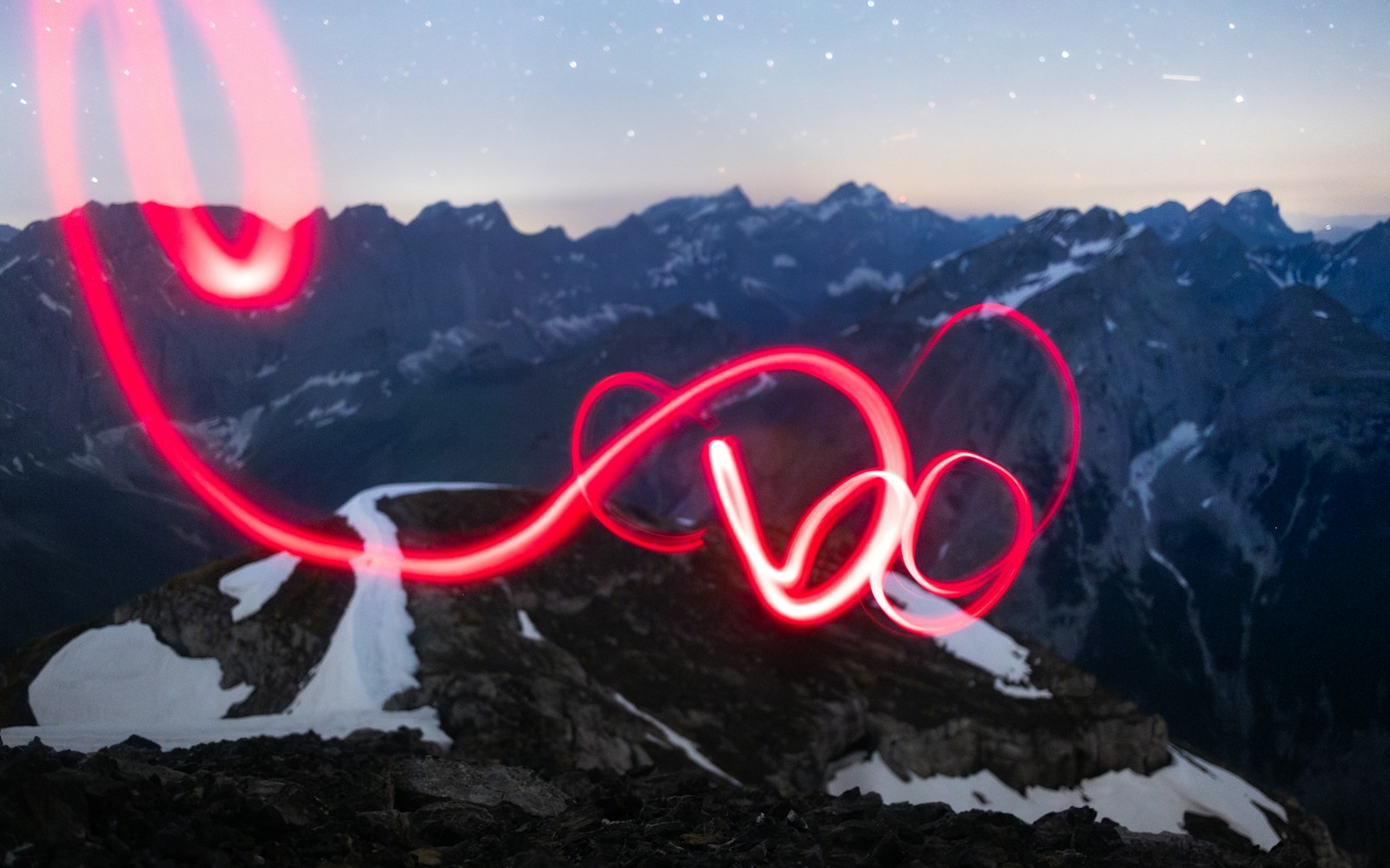 A long exposure photo of a red light on a mountain